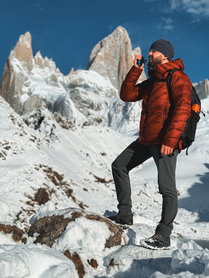 Man with backpack enjoys mountain view at snowy Fitz Roy, Argentina.